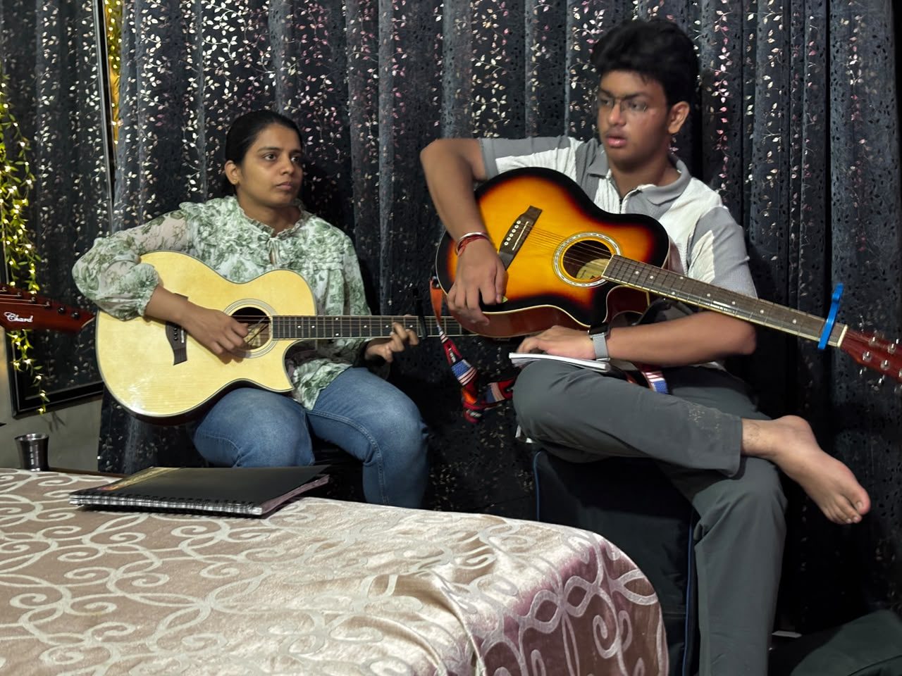 Two students practicing guitar together during an offline class