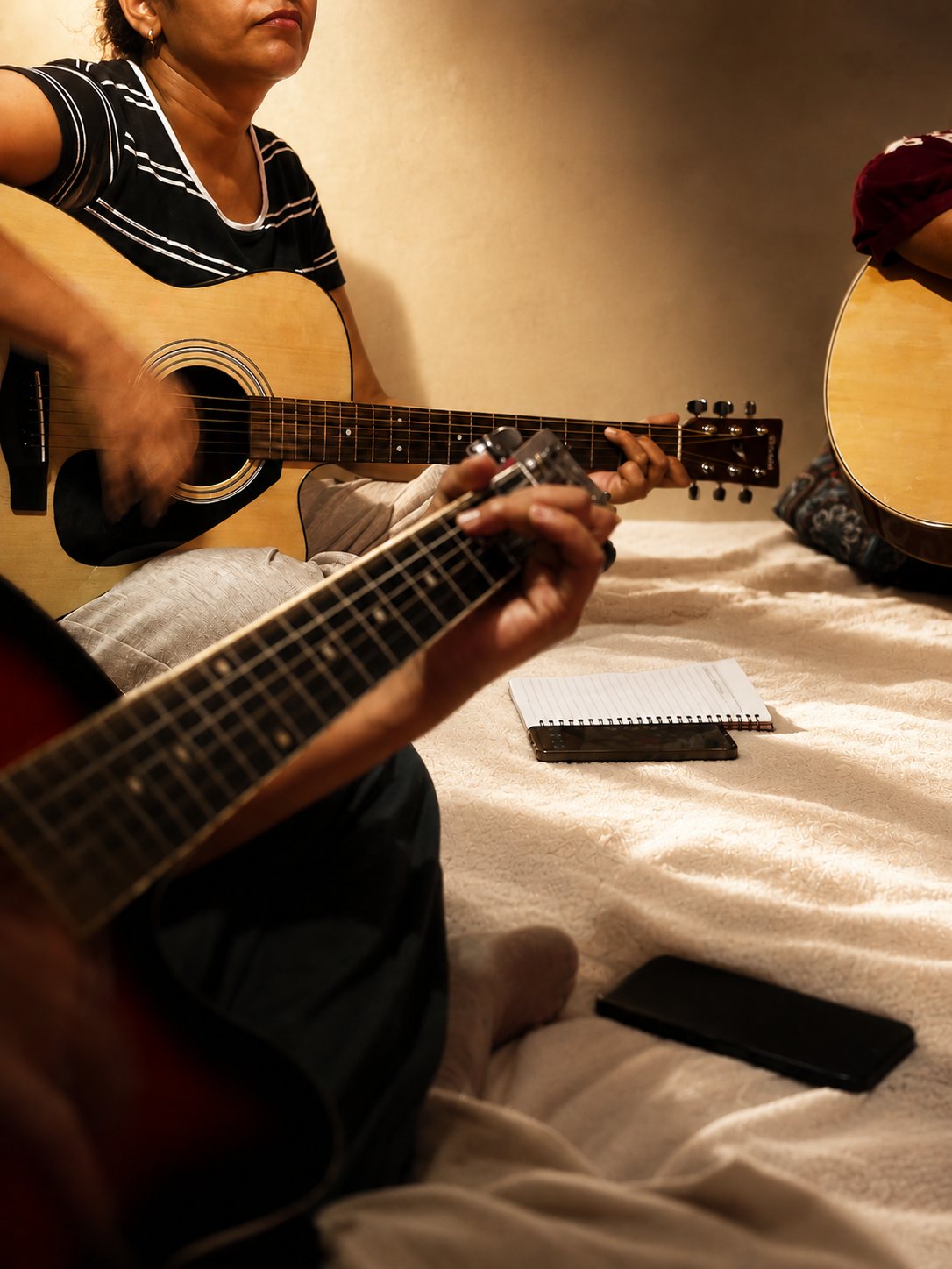A student fretting a chord during a Natural Tune guitar class
